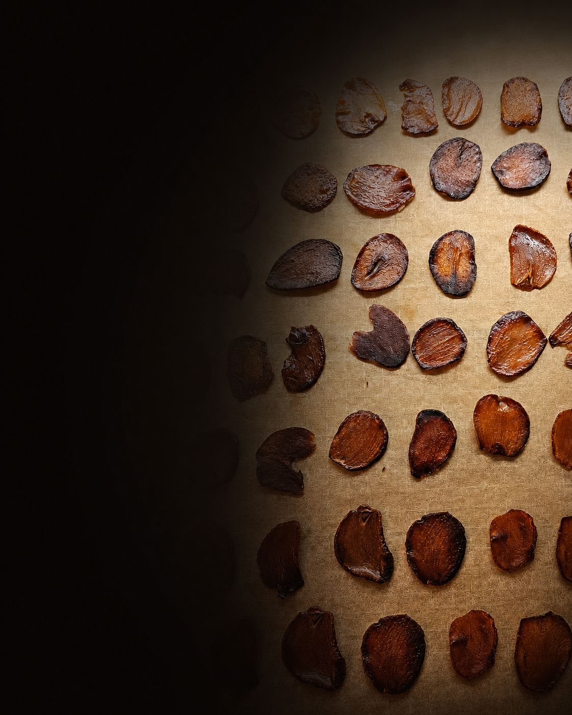 Dunne knoflookchips met warme belichting op bakpapier